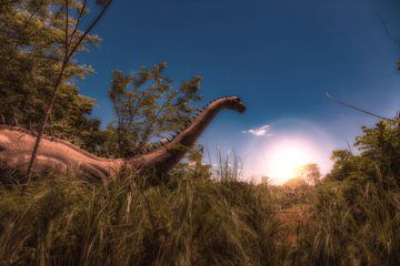 Dinosaurussen in het hoge gras bij zonsopgang of zonsondergang van Jan Schneckenhaus