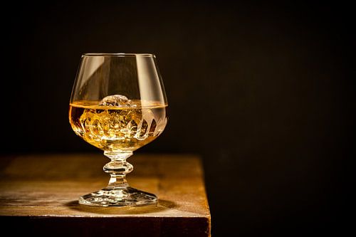 Glas met Whisky en IJs tegen Zwaarte achtergrond