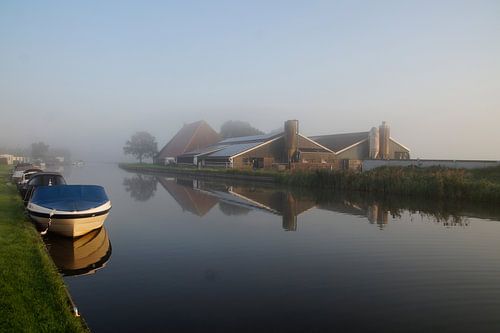 opkomende boerderij  in de ochtend mist aan het water