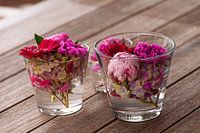 Prachtige verse gemengde bloemen gerangschikt in glazen vazen op houten tafel
