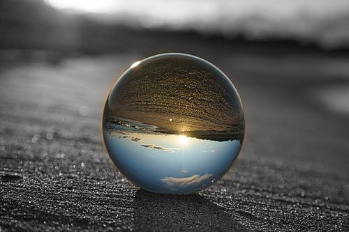 Uitzicht door de glazen bol op het strand. Zee en lucht op de achtergrond.