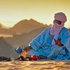 Sahara woestijn. Toeareg man zet thee op het zand van Frans Lemmens