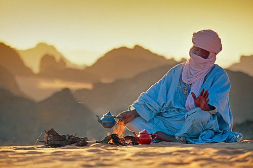 Sahara desert. Tuareg man makes tea on the sand