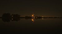 Nachtfoto van windmolen aan het water
