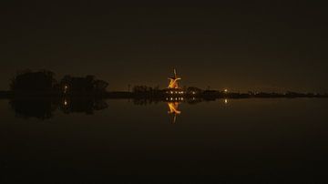 Nachtfoto van windmolen aan het water van Rob Baken