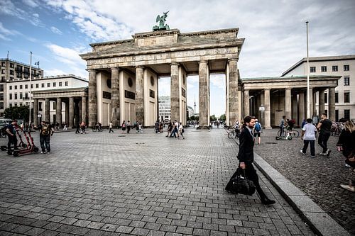 Brandenburger tor in berlijn met man met tas en steppen