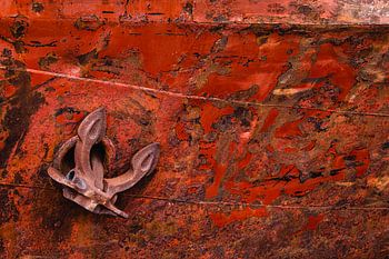 Anker tegen boeg van een met roest uitgeslagen schip
