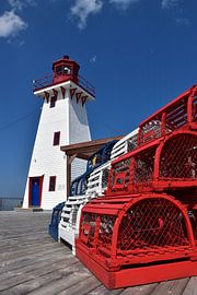 The small lighthouse under a blue sky by Claude Laprise