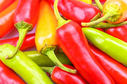 Un tas de piments rouges, orange et verts très forts