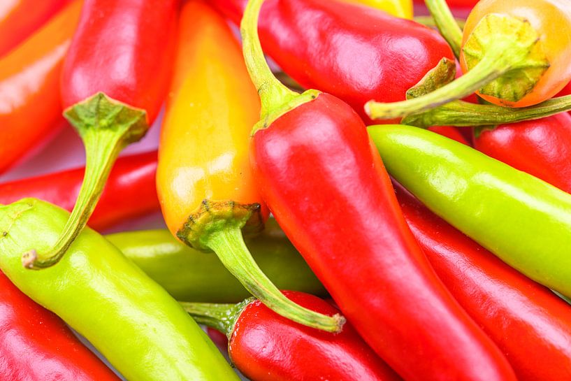 Stapel van hete rode, oranje en groene Chili pepers van Sjoerd van der Wal Fotografie