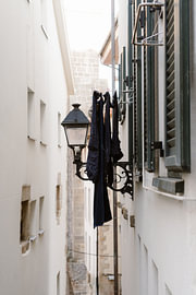 Dark blue laundry hanging from a lamppost, Spain by AIM52 Shop