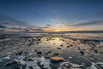 De pier komt tevoorschijn wanneer de Noordzee zich terugtrekt tijdens een kleurrijke zonsondergang van Bram Lubbers