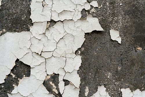 Afbladderende witte verf op een gevel