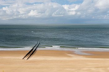 Ein menschenleerer Strand bei Zoutelande mit einer Reihe von Wellenbrechern