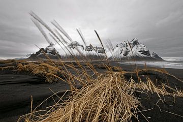Bergketen achter zwarte zandduinen in IJsland