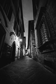 A narrow, dark alleyway in black and white