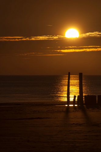 Golfbrekers in de zonsondergang.