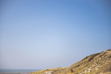 Paysage côtier avec dunes, mer et ciel bleu clair sur Simone Janssen