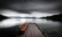 Een mystiek landschap in Noorwegen in zwart-wit met een meer. Een leeg bankje staat op een steiger b van Bas Meelker thumbnail