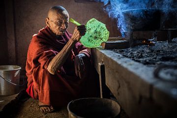Norse monnik kookt in een ouderwetse keuken in een budhistisch klooster in de omgevinf van Inle in M