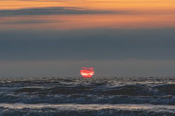 Ondergaande zon die versmelt met de zee bij Terschelling
