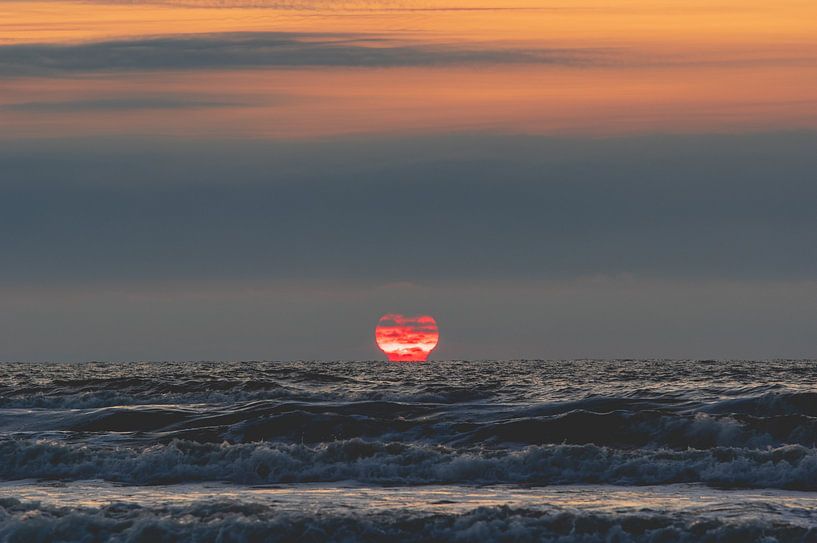 Ondergaande zon die versmelt met de zee bij Terschelling van Alex Hamstra