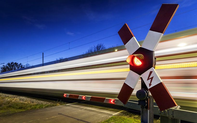 Bahnübergang mit vorbeirasendem Zug von Frank Herrmann