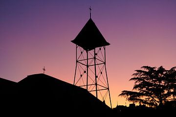 Silhouet van een klokkentoren bij zonsondergang