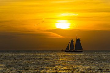 USA, Florida, Beeindruckender orangefarbener Sonnenuntergang hinter einem Zweimaster-Segelboot von adventure-photos