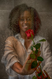 Woman with a red rose behind a window by Edward Draijer