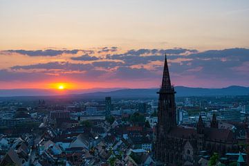 Deutschland, Roter Sonnenuntergang hinter Vogesen über Stadt Freiburg i von adventure-photos