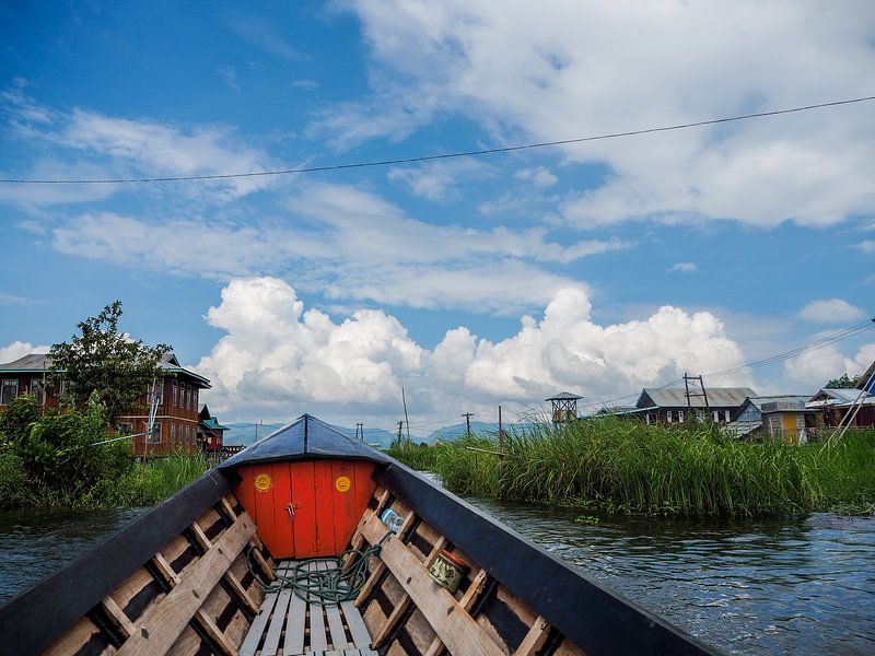 Op een boot in Myanmar (Birma) met zicht op paalwoningen. van Sofie Duchateau
