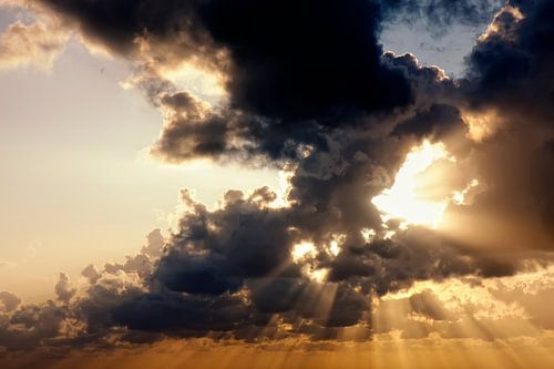 Zonnestralen door wolken