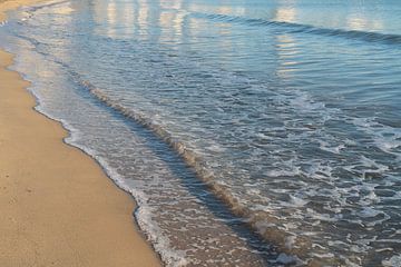 Wellen gleiten sanft an den Sandstrand