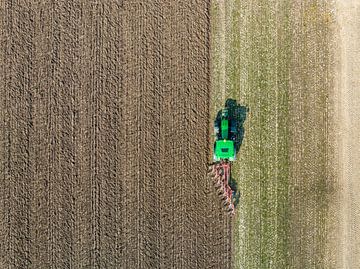 Tractor maakt de grond klaar voor het planten van gewassen van bovenaf gezien van Sjoerd van der Wal Fotografie