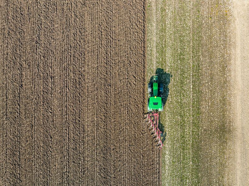 Tractor maakt de grond klaar voor het planten van gewassen van bovenaf gezien van Sjoerd van der Wal Fotografie