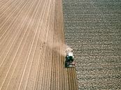 Tractor maakt de grond klaar voor het planten van gewassen van bovenaf gezien van Sjoerd van der Wal Fotografie thumbnail