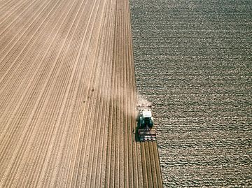 Tractor maakt de grond klaar voor het planten van gewassen van bovenaf gezien van Sjoerd van der Wal