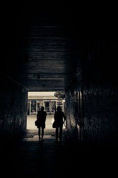 Passage in the shade - silhouettes in the urban tunnel