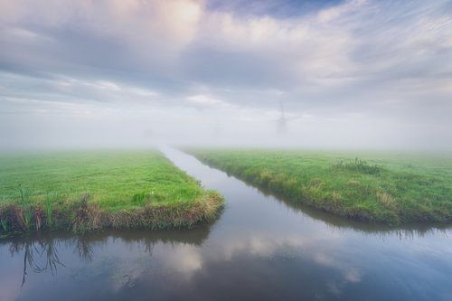 Morgennebel über holländischer Landschaft mit Windmühle und spiegelnden Wolken im Wasser von Original Mostert Photography