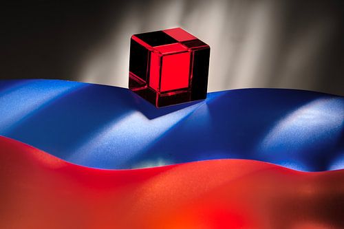 Roter Würfel auf blauem, orangefarbenem gewelltem Hintergrund. von Gerhard de Wit