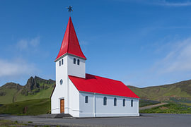 Víkurkirkja – Red church on a green hill by Paysages urbains - Rick Van der Poorten Photography