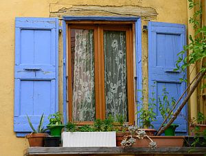 Blaue Fensterläden und gelbe Wand in Crest