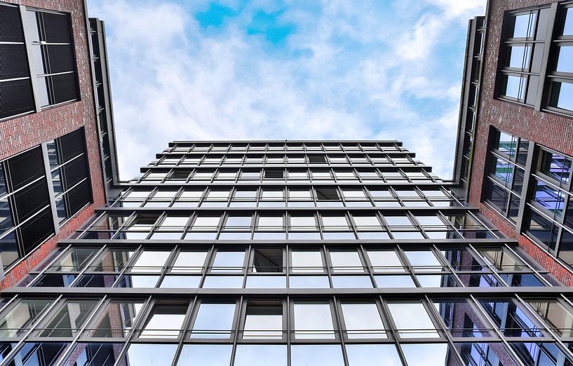 Façade réfléchissante d'immeubles de bureaux modernes sous un ciel bleu par MPfoto71