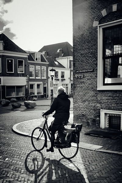 Straatfotografie in Utrecht. De fietser in de Jacobijnenstraat. van André Blom Fotografie Utrecht