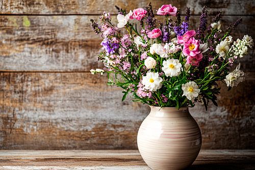 Kleurrijke bloemen in keramische vaas