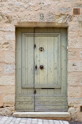 old pastel green door in a stone building