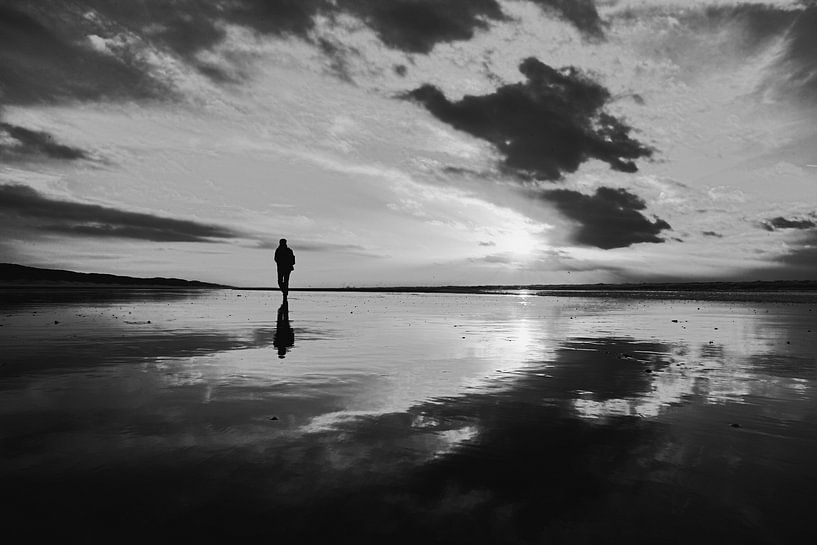 wandelen op het Noordzeestrand bij een ondergaande zon von eric van der eijk