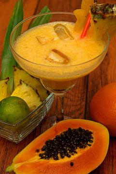 Tropische cocktail met ananas, limoen, papaya, sinaasappel.