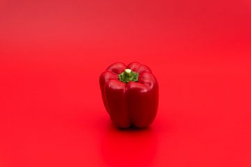 Rode paprika op rode achtergrond van Wim Stolwerk